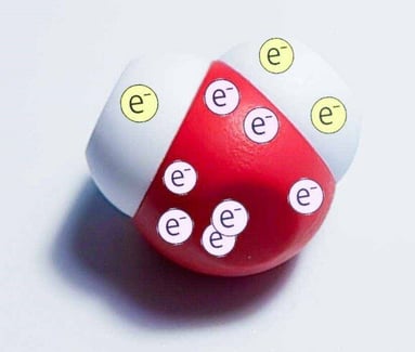 Model of a water molecule with 1 electron displayed on one hydrogen atom, 2 electrons displayed on the other hydrogen, and 7 electrons on the oxygen atom.